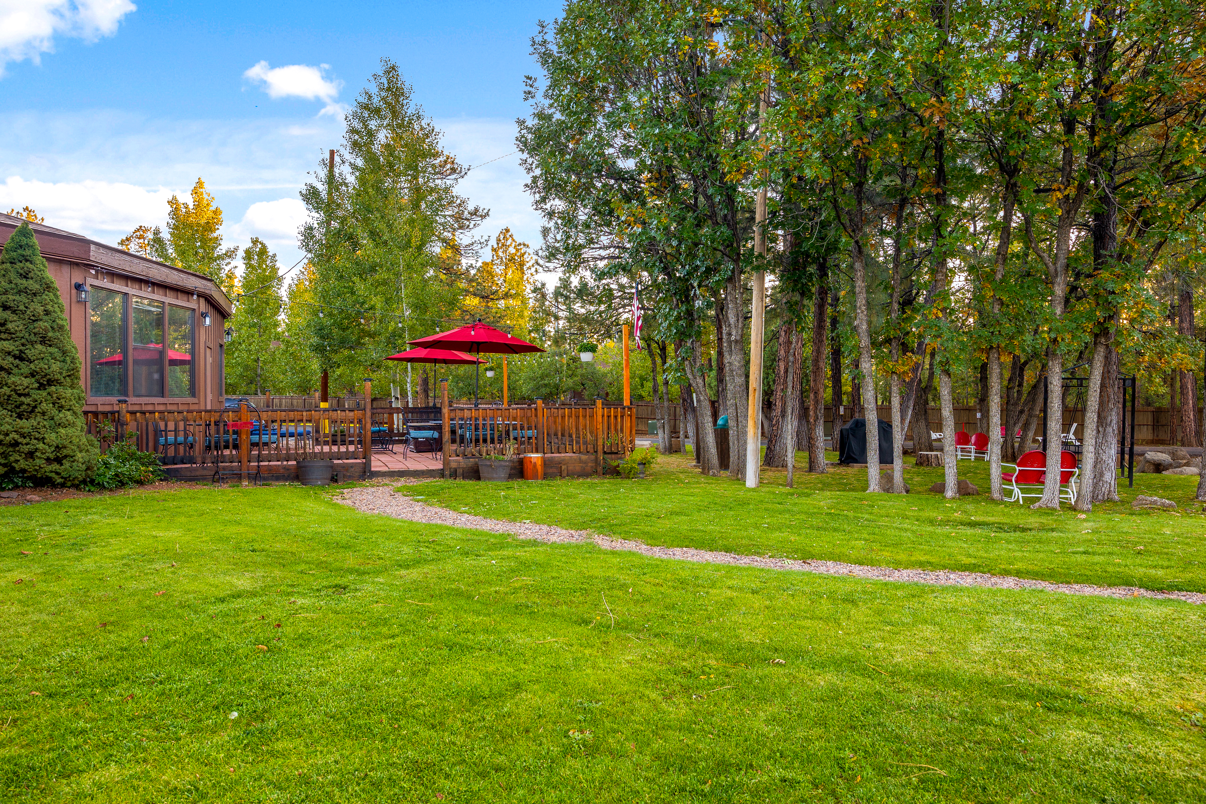 Resort green lawn and deck area surrounded by tall pines
